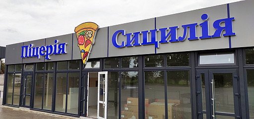 Світлова вивіска на фасаді піцерії у вигляді букв та лайтбокса - шматок піци.
